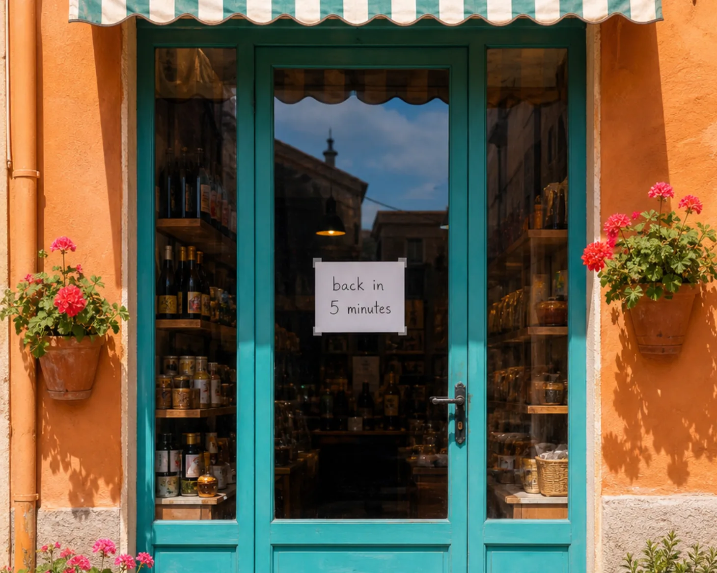 A shop door locked at night with a handwritten back in five minutes note taped to the glass.